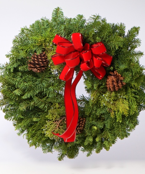 Evergreen wreath tied with a red bow with pine cone accents